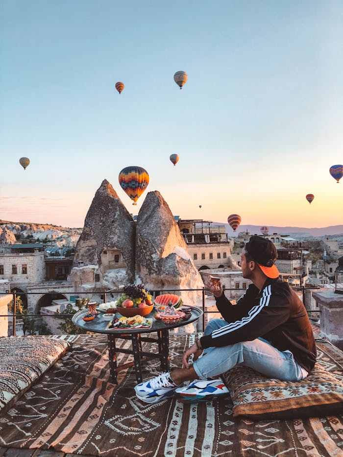 Man Sitting with View on Balloons over Cappadocia